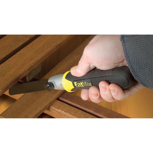 STANLEY 0-20-220 FatMax folding saw with black and yellow handle cutting wood, close-up in use.