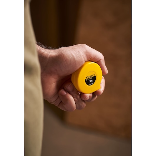 STANLEY 0-32-189 yellow tape measure held in hand, close-up photography.