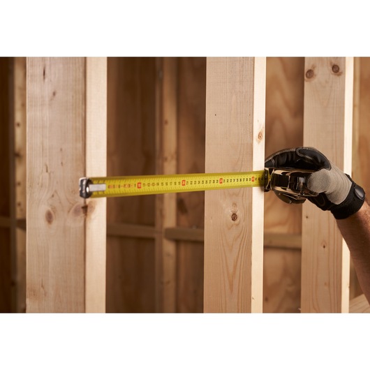 STANLEY 0-33-532 tape measure photography, measuring wooden studs, side angle.