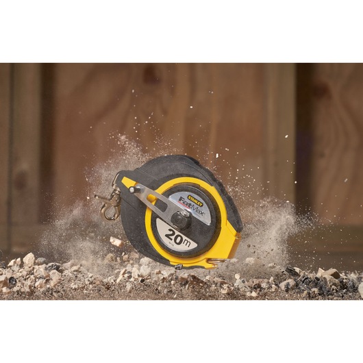 STANLEY 0-34-133 tape measure, 20m, black and yellow, shown on construction site with dust and rocks.
