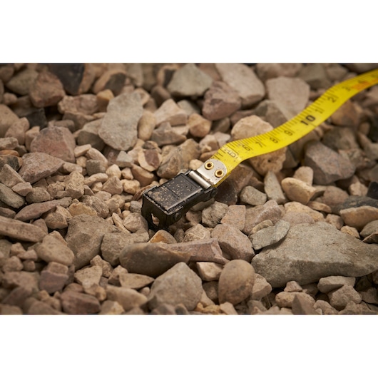 STANLEY 0-34-296 yellow tape measure on rocky ground, close-up photography.
