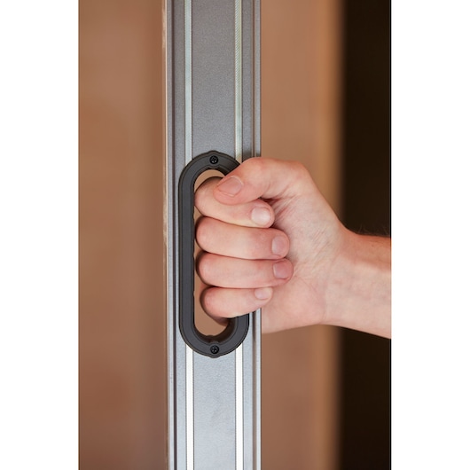 Photo of a hand holding a STANLEY 0-43-648 level tool by its black ergonomic handle.