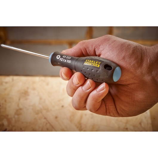 STANLEY 0-65-335 screwdriver with black and yellow handle held in hand, close-up view.