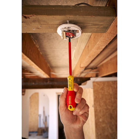 STANLEY 0-65-419 insulated screwdriver used to install electrical wiring, shown in a hand during ceiling work.