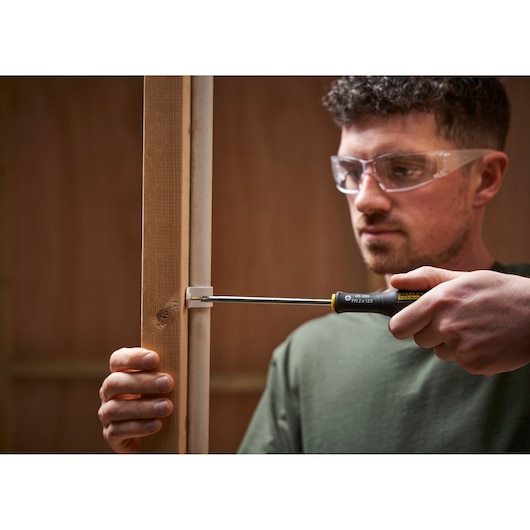 Photo of STANLEY 0-65-437 screwdriver used to fasten screw into wood frame.