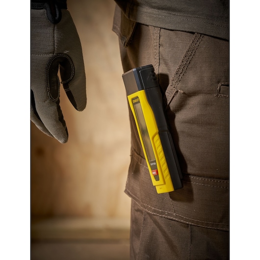 STANLEY 0-77-030 laser distance measurer in yellow and black clipped to brown work pants, side view.