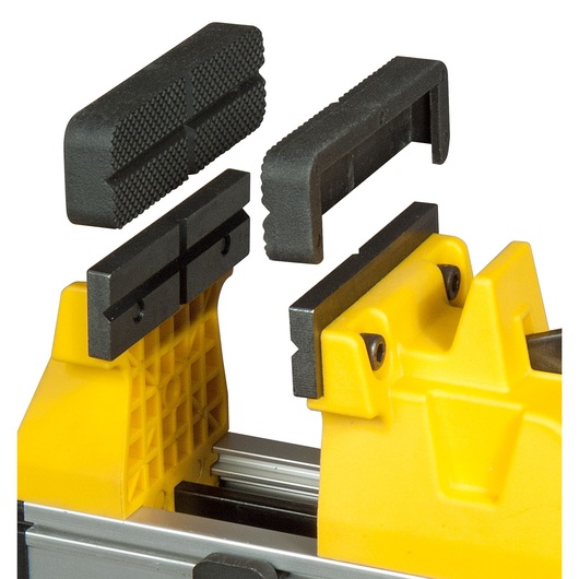 Close-up of a yellow Stanley vise with detachable black textured jaw inserts shown above.