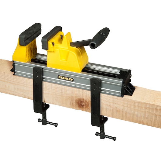STANLEY 0-83-179 woodworking clamp with yellow handle and metal body, side angle on wooden beam.