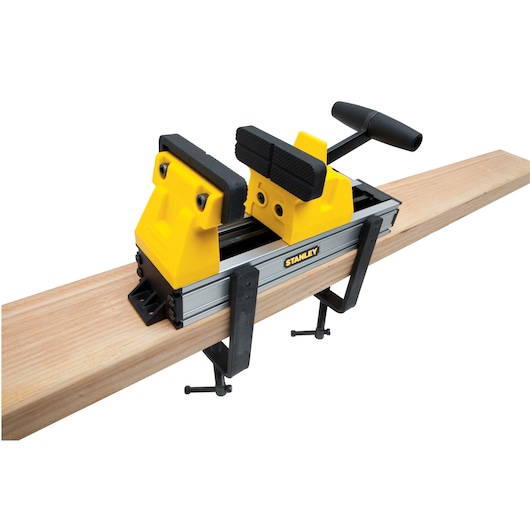 STANLEY 0-83-179 portable workbench vise mounted on wood plank, photographed from angle on white background.