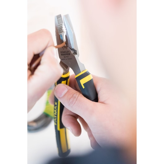 Photo of STANLEY 0-89-867 pliers with yellow and black grips being used to grip a brown wire.