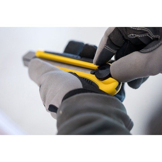 STANLEY 1-10-425 utility knife in use, close-up of gloved hands adjusting yellow knife.