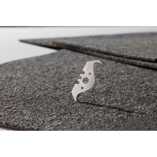 STANLEY 1-11-967 trapezoidal utility blade on gray carpet tiles, close-up, photography.