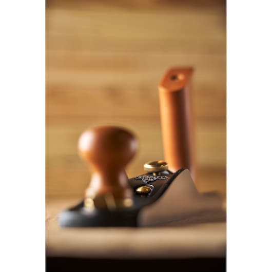 STANLEY 1-12-137 hand plane with wood handles, side angle, on wood surface.