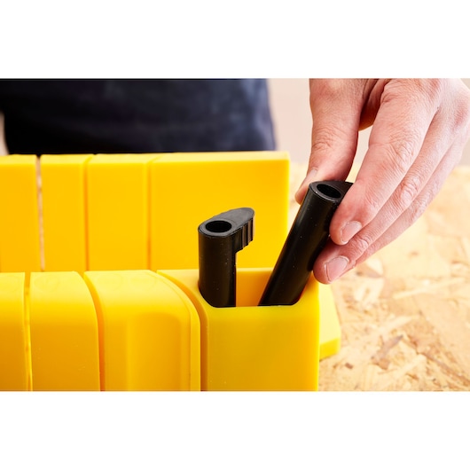 STANLEY 1-20-600 photography of yellow mitre box with hand placing black saw accessory.