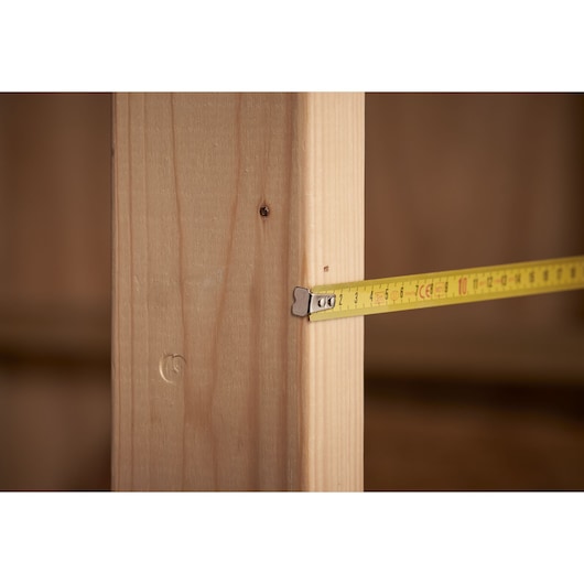 STANLEY 1-30-299 tape measure extended to wood beam, close-up photo.