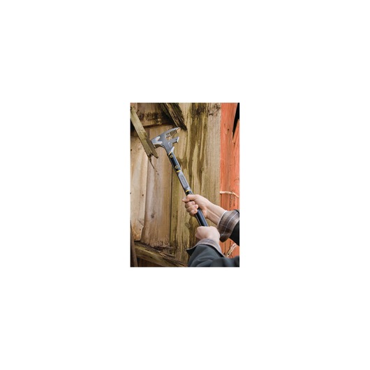Stanley 1-55-120 demolition tool in use against wood, hand gripping black and yellow handle.