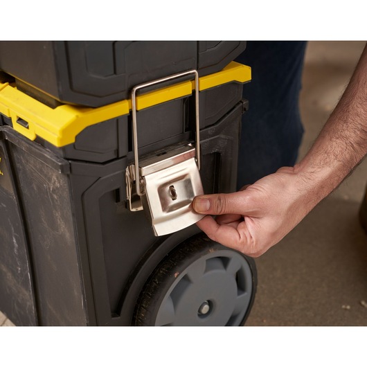STANLEY 1-70-326 tool box close-up, showing large metal latch being opened by hand, black and yellow design.