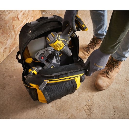 STANLEY 1-79-215 tool backpack with yellow accents, photographed from above, filled with tools on worksite.