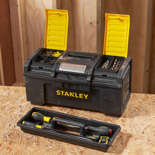 Photo of STANLEY 1-79-217 black and yellow toolbox with open compartments, tray with hand tools, on wooden surface.