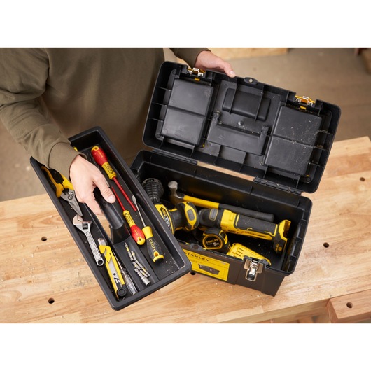 STANLEY 1-92-066 toolbox photography featuring assorted hand and power tools on a wooden table, top angle.