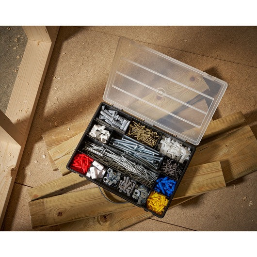 STANLEY 1-92-761 organizer box top view with assorted screws, anchors, nuts and bolts on workshop floor.