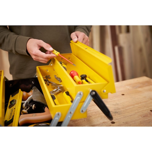 STANLEY 1-94-738 yellow metal toolbox with assorted hand tools, photo from above on a workbench.