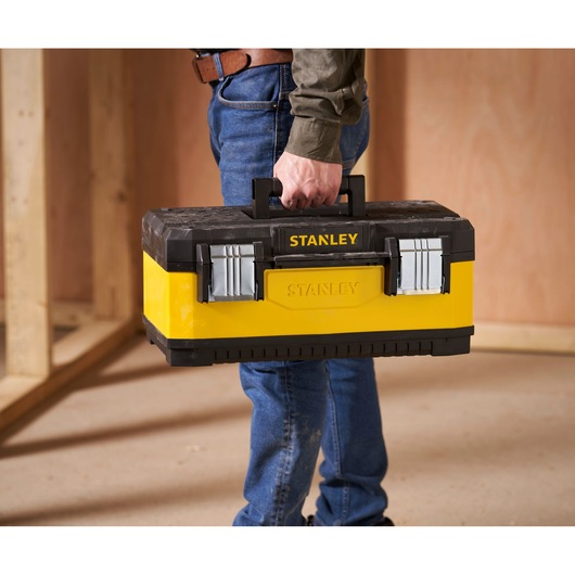 STANLEY 1-95-612 yellow and black toolbox held by a person in a construction setting