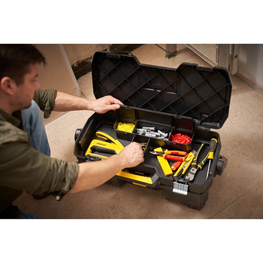 Stanley 1-97-506 tool box with organized tools and accessories, open, in use on a workshop floor.