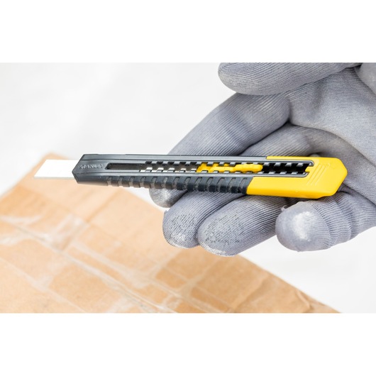 STANLEY 2-10-150 utility knife with black and yellow handle, shown held above a cardboard box.