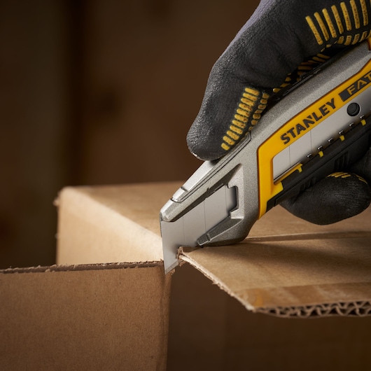 STANLEY 2-11-301 utility knife cutting cardboard, close-up photography.