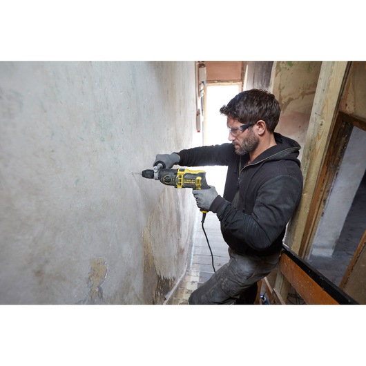 Photo of a person drilling a wall with a STANLEY FMEH850K corded hammer drill.
