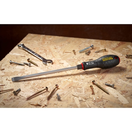 Stanley FMHT0-62621 flathead screwdriver with ergonomic handle on plywood amid screws and wrench.