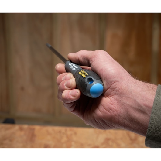 STANLEY FMHT0-62624 screwdriver with black and blue handle held in hand, photography in workshop setting.