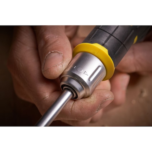 Close-up photo of STANLEY FMHT0-62691 screwdriver handle with yellow and black grip held in a hand.