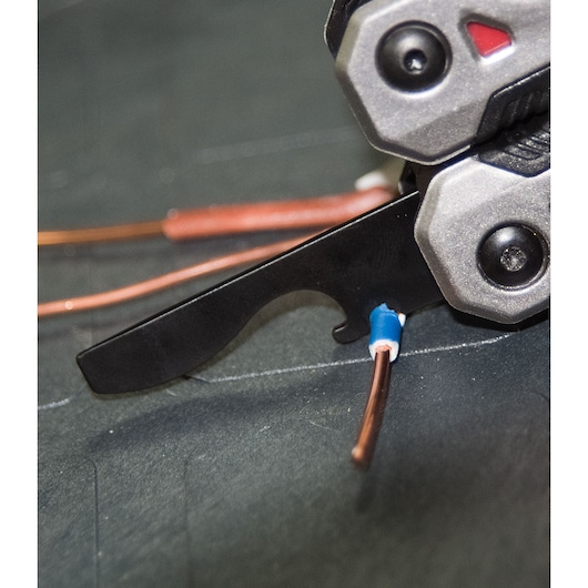 STANLEY FMHT0-72414 plier tool close-up stripping copper wire on dark surface.