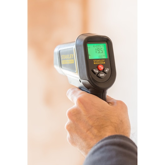 STANLEY FMHT0-77422 infrared thermometer, handheld, close-up of display and controls in use.