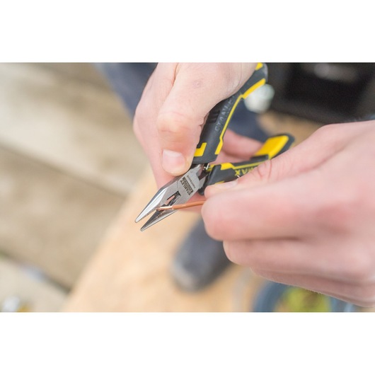Photo of STANLEY FMHT0-80541 pliers with black and yellow handle cutting a copper wire.