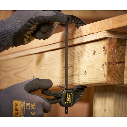 STANLEY FMHT0-83231 trigger clamp used to secure wood, close-up view.
