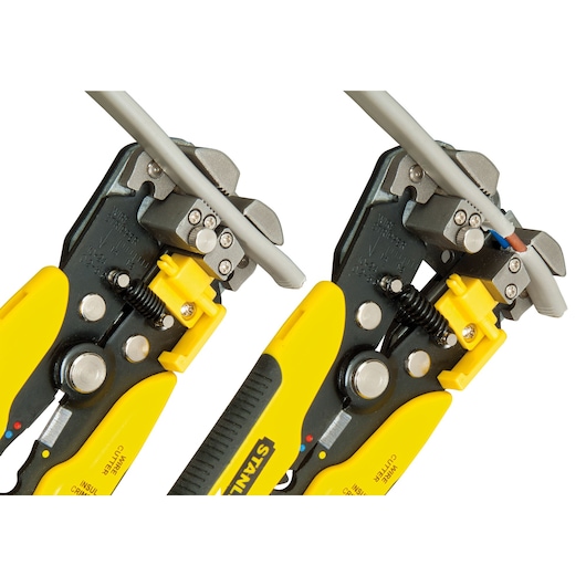 STANLEY FMHT0-96230 wire stripper with yellow and black handle, shown stripping electrical cable, close-up angle.