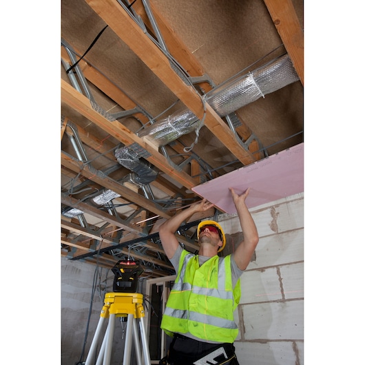 STANLEY FMHT1-77357 laser level tripod in use during ceiling installation, construction site photography.