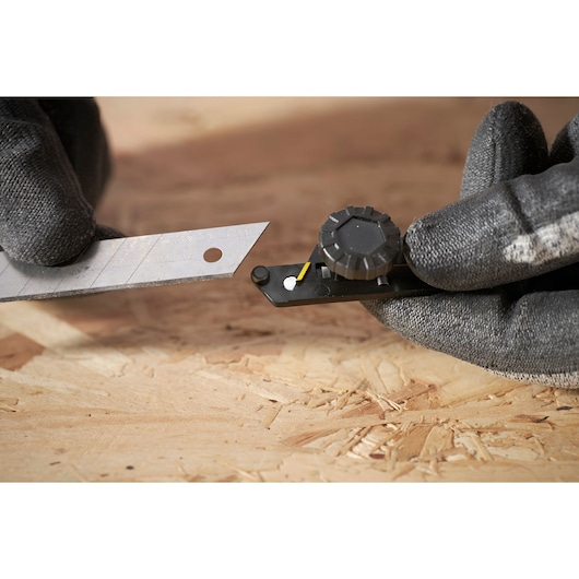 STANLEY FMHT10592-0 blade snapper tool with blade, close-up on wooden surface.
