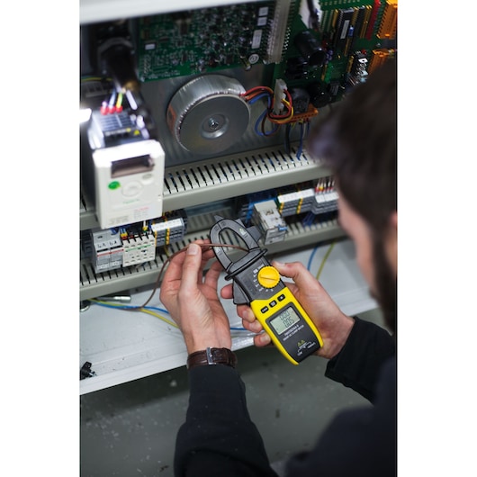 Photo of STANLEY FMHT82564-0 clamp meter in use measuring electrical current in an open control panel.