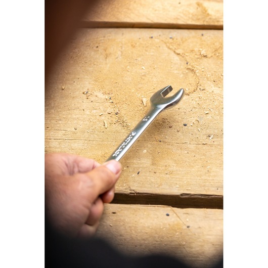 STANLEY FMMT13030-0 wrench held in hand on wooden surface, close-up photography.