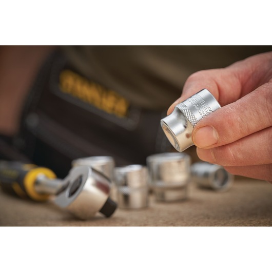STANLEY FMMT17217-0 socket set photography, close-up of silver sockets and ratchet tool on work surface.