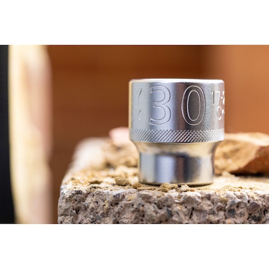 Photo of STANLEY FMMT17218-0 chrome socket, 30mm, photographed on a rough stone surface, close-up view.