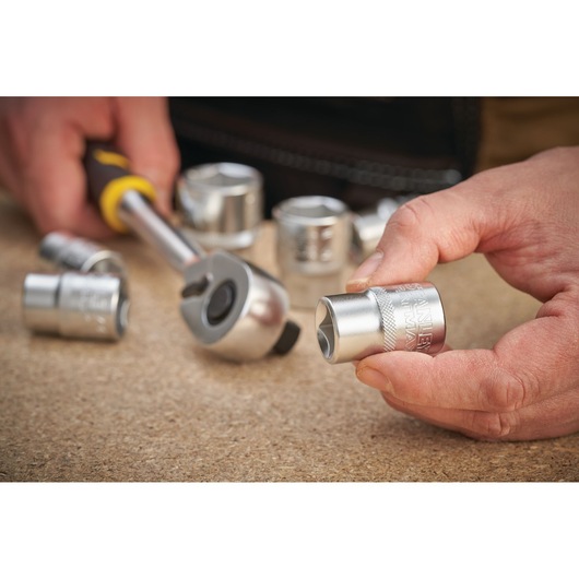 STANLEY FMMT17242-0 socket set photography, close-up of silver sockets and ratchet tool on tabletop.