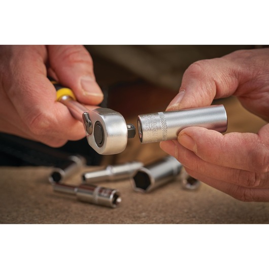 STANLEY FMMT17966-0 ratchet wrench and socket being assembled, close-up, with other sockets blurred in background.