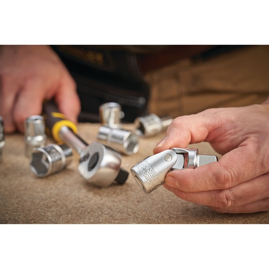 Photo of STANLEY FMMT17999-0 socket set with ratchet, hand holding silver socket, tabletop view.