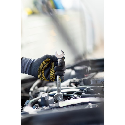 STANLEY FMMT82901-0 spanner in gloved hand tightening bolt in engine bay, close-up photography.