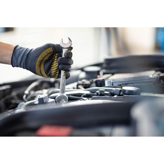 Photo of STANLEY FMMT82901-0 wrench being used on a car engine by a gloved hand.